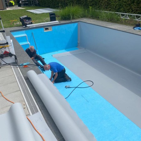 De nieuwe  grijze  liner wordt geplaatst - Ons Zwembad 